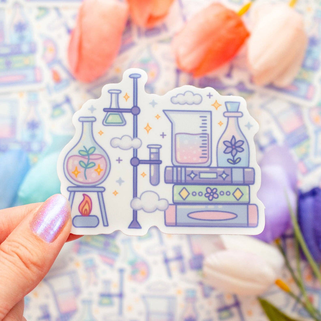 Sticker with laboratory design held by a hand against a blurred floral background